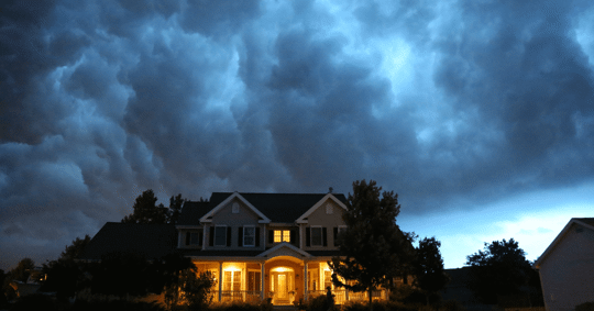 house with lights on during storm