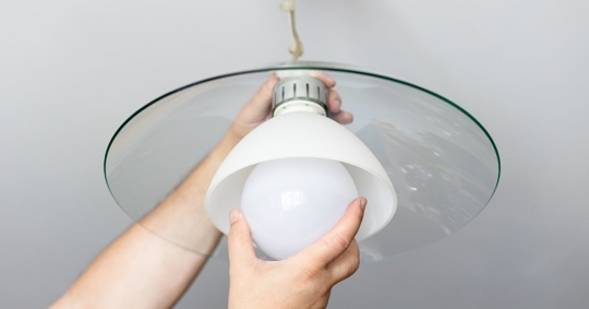 person changing LED light bulb